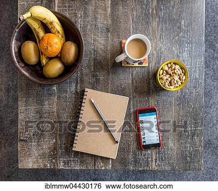 Notes on smartphone, notebook with pen, coffee, fruit and nuts, snacks on a wooden table View Large Photo Image Stock Photograph - Notes on smartphone, notebook with pen, coffee, fruit and nuts, snacks on a wooden table. Fotosearch