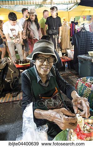 Old woman, Thai woman sells flowers and flower chains at the Night Market, Krabi Town, Krabi Province, Thailand, Asia View Large Photo Image Stock Photo - Old woman, Thai woman sells flowers and flower chains at the Night Market, Krabi Town, Krabi Province, Thailand, Asia. Fotosearch