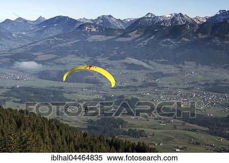 Stock Photography - Paragliders, behind Allgäu Alps with Grünten, Allgäu, Bavaria, Germany, Europe. Fotosearch