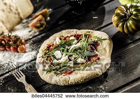 Pizza on dark wooden table, tomatoes, arugula, cheese, South Tyrol, Italy, Europe View Large Photo Image Stock Image - Pizza on dark wooden table, tomatoes, arugula, cheese, South Tyrol, Italy, Europe. Fotosearch