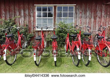 Stock Photograph - Red bicycles in front of wooden house, bicycle rental, Norderney, Lower Saxony, Germany, Europe. Fotosearch