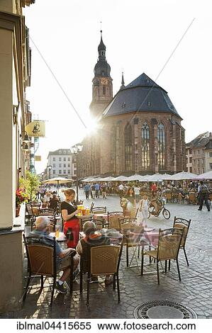 Restaurants and outdoor cafes along the marketplace with Church of the Holy Spirit in Heidelberg, Baden-Württemberg, Germany, Europe View Large Photo Image Stock Photography - Restaurants and outdoor cafes along the marketplace with Church of the Holy Spirit in Heidelberg, Baden-Württemberg, Germany, Europe. Fotosearch