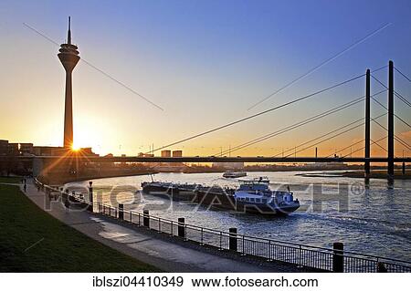 Rhine with cargo ship, Rhine Tower and Rheinkniebrücke, bridge at sunset, Düsseldorf, North Rhine-Westphalia, Germany, Europe View Large Photo Image Stock Photo - Rhine with cargo ship, Rhine Tower and Rheinkniebrücke, bridge at sunset, Düsseldorf, North Rhine-Westphalia, Germany, Europe. Fotosearch