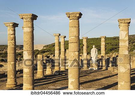 Stock Photograph - Ruins with statue of emperor Trajano, archeological site Baelo Claudia, Bolonia, Cadiz Province, Costa de la Luz, Andalusia, Spain, Europe. Fotosearch