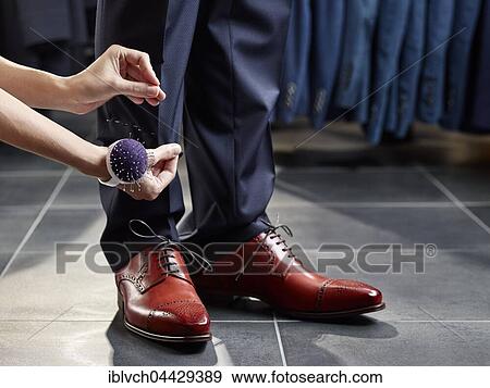 Stock Photo - Seamstress with pincushion, fastening pins onto pants, Austria, Europe. Fotosearch