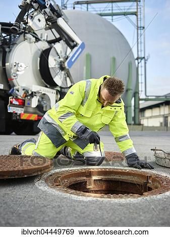 Stock Photo - Sewer cleaning, gas storage facility, worker inspecting channel with flashlight, Innsbruck, Tyrol, Austria, Europe. Fotosearch