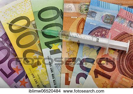 Symbolic picture Costs of mass vaccination against Covid-19, syringe lies on EURO banknotes, corona crisis, Baden-Württemberg, Germany, Europe View Large Photo Image Picture - Symbolic picture Costs of mass vaccination against Covid-19, syringe lies on EURO banknotes, corona crisis, Baden-Württemberg, Germany, Europe. Fotosearch