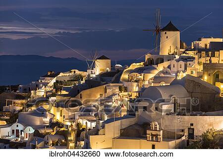 Stock Image - Town, windmills, evening light, Oia, Santorini, Cyclades, Greece, Europe. Fotosearch