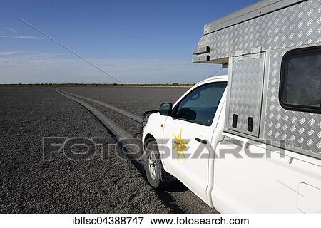 Stock Photo - Truck with camper driving through Deception Pan in Deception Valley of the Central Kalahari Game Reserve, Botswana, Africa. Fotosearch