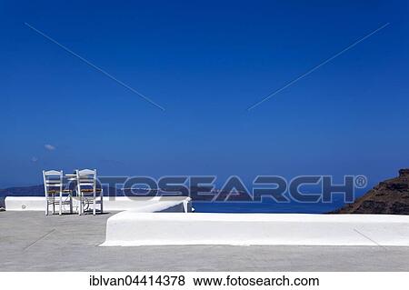 Two chairs with table on a terrace, Thira, Fira, Santorini, Cyclades Islands, Greece, Europe View Large Photo Image Stock Photo - Two chairs with table on a terrace, Thira, Fira, Santorini, Cyclades Islands, Greece, Europe. Fotosearch