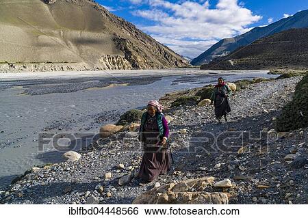 Two local women walking at river, near Jomsom, Kali Gandaki valley, Mustang District, Nepal, Asia View Large Photo Image Stock Photograph - Two local women walking at river, near Jomsom, Kali Gandaki valley, Mustang District, Nepal, Asia. Fotosearch