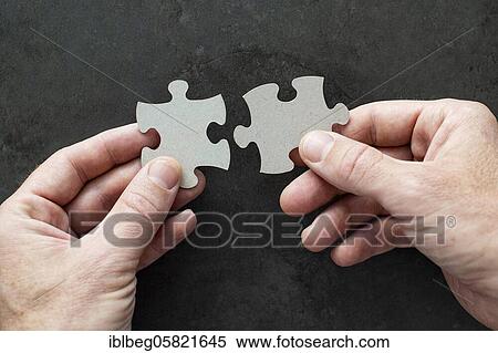 Two puzzle pieces in your hands View Large Photo Image Stock Photography - Two puzzle pieces in your hands. Fotosearch