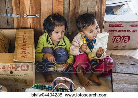 Two small children sit on the floor and eat sweets, Inle Lake, Shan State, Myanmar, Asia View Large Photo Image Stock Photography - Two small children sit on the floor and eat sweets, Inle Lake, Shan State, Myanmar, Asia. Fotosearch