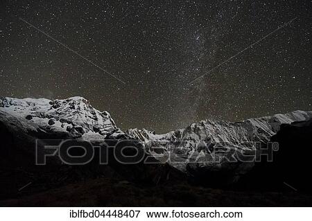 View of the snow covered Annapurna 1 North Face, mid, and the Annapurna South summit, left at night with stars and Milky Way, Chomrong, Kaski District, Nepal, Asia View Large Photo Image Stock Photo - View of the snow covered Annapurna 1 North Face, mid, and the Annapurna South summit, left at night with stars and Milky Way, Chomrong, Kaski District, Nepal, Asia. Fotosearch
