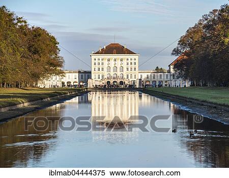 Stock Photography - West side of Nymphenburg Palace, reflected in castle garden channel, autumn, Munich, Upper Bavaria, Bavaria, Germany, Europe. Fotosearch