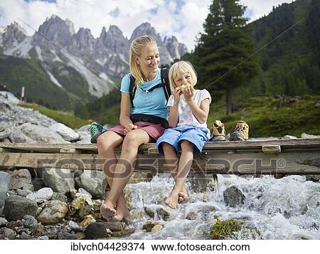 Woman, 25-30 years, blonde hair, sitting with daughter on bridge, Kemater Alm, Tyrol, Austria, Europe View Large Photo Image Picture - Woman, 25-30 years, blonde hair, sitting with daughter on bridge, Kemater Alm, Tyrol, Austria, Europe. Fotosearch