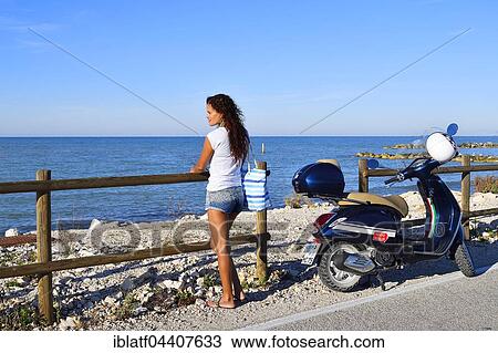 Woman gazing out at the sea next to Vespa Primavera scooter, Marina di Montemarciano, Indian, Alaska Marche, Italy, Europe View Large Photo Image Stock Image - Woman gazing out at the sea next to Vespa Primavera scooter, Marina di Montemarciano, Indian, Alaska Marche, Italy, Europe. Fotosearch