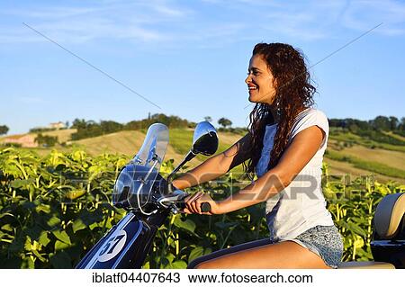 Woman on Vespa Primavera scooter in front of sunflower field, Sant' Amico, Morro d' Alba, Marche, Italy, Europe View Large Photo Image Stock Image - Woman on Vespa Primavera scooter in front of sunflower field, Sant' Amico, Morro d' Alba, Marche, Italy, Europe. Fotosearch