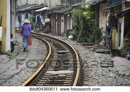 Woman with straw hat walking near train tracks, Hanoi, Vietman View Large Photo Image Stock Image - Woman with straw hat walking near train tracks, Hanoi, Vietman. Fotosearch
