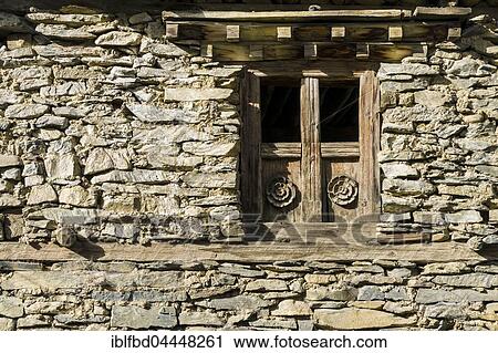Stock Image - Wooden paneled window of an old stone house, Ngawal, Manang, Nepal, Asia. Fotosearch