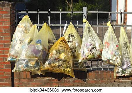 Stock Photography - Yellow bags with plastic waste, hanging on garden fence, waste separation, Lower Saxony, Germany, Europe. Fotosearch