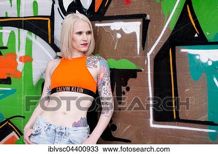 Young blond tattoo model posing at graffiti wall, Germany, Europe View Large Photo Image Stock Image - Young blond tattoo model posing at graffiti wall, Germany, Europe. Fotosearch