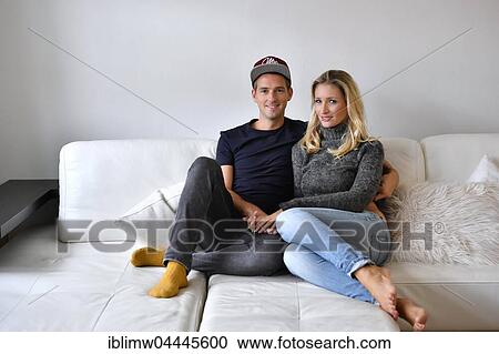 Young couple, lovers sitting on sofa View Large Photo Image Stock Image - Young couple, lovers sitting on sofa. Fotosearch
