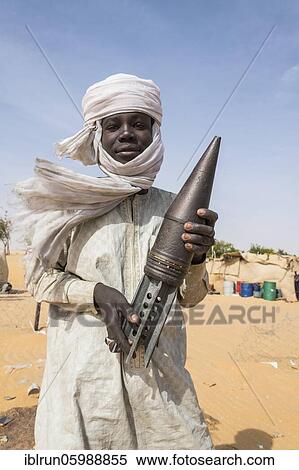 Young Man posing with an old rockethead, between Faya-Largeaux and N'Djamena, Sahara, Chad, Africa View Large Photo Image Stock Photography - Young Man posing with an old rockethead, between Faya-Largeaux and N'Djamena, Sahara, Chad, Africa. Fotosearch