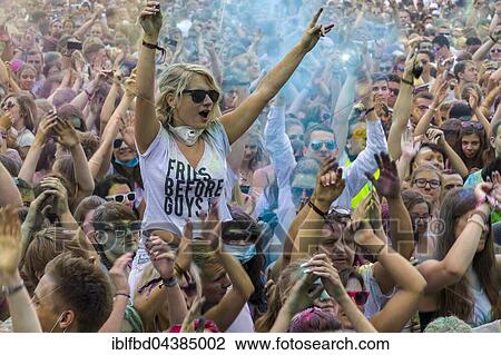 A young woman is sitting on another ones shoulders, raising arms, in the crowd at the colorful Holi festival, Dresden, Saxony, Germany, Europe View Large Photo Image Stock Image - A young woman is sitting on another ones shoulders, raising arms, in the crowd at the colorful Holi festival, Dresden, Saxony, Germany, Europe. Fotosearch