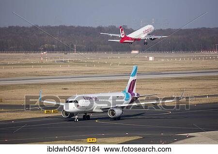 Aircraft euro Wings on Runway and Airberlin taking off, Düsseldorf Airport, Düsseldorf, North Rhine-Westphalia, Germany, Europe View Large Photo Image Picture - Aircraft euro Wings on Runway and Airberlin taking off, Düsseldorf Airport, Düsseldorf, North Rhine-Westphalia, Germany, Europe. Fotosearch
