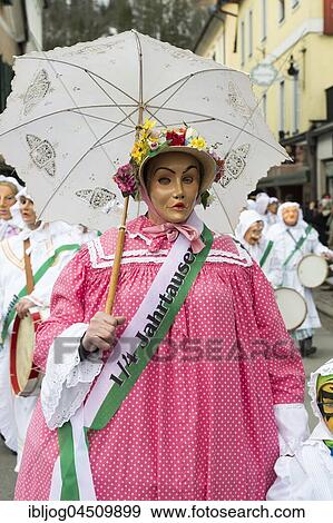 Stock Photo - Aussee Carnival, Man with mask, called Dudl, straw hat with flowers, parasol, Trommelweiber, Bad Aussee, Styria, Austria, Europe. Fotosearch