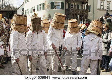 Stock Image - Aussee Carnival, men in white suits, even Pless, woven baskets on heads, Bad Aussee, Styria, Austria, Europe. Fotosearch