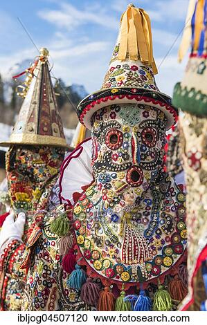 Stock Image - Ausseer Flinserl disguised people in costume with face masking or Gugl and hat, sequins, different appliqué designs, Bad Aussee, Styria, Austria, Europe. Fotosearch