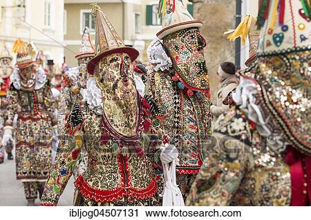 Stock Image - Ausseer Flinserl disguised people in costume with face masking or Gugl and hat, ruff or Kress, Bad Aussee, Styria, Austria, Europe. Fotosearch