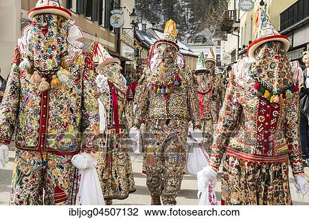 Stock Image - Ausseer Flinserl disguised people in costume with face masking or Gugl and hat, ruff or Kress, Bad Aussee, Styria, Austria, Europe. Fotosearch