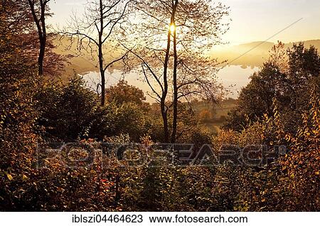 Autumnal forest and lake, Schalkenmehrener Maar at sunrise, Schalkenmehren, Daun, Vulkaneifel, Eifel, Rhineland-Palatinate, Germany, Europe View Large Photo Image Stock Image - Autumnal forest and lake, Schalkenmehrener Maar at sunrise, Schalkenmehren, Daun, Vulkaneifel, Eifel, Rhineland-Palatinate, Germany, Europe. Fotosearch