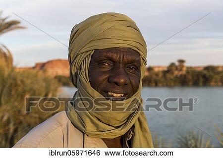 Stock Photograph - Beduin at the shore of Ounianga kebir part of the the Unesco sight Ounianga lakes, northern Chad, Africa. Fotosearch