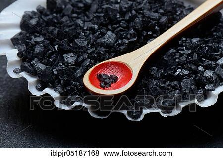 Stock Photo - Black Hawaiian salt in shell with spoon, sea salt with activated carbon. Fotosearch