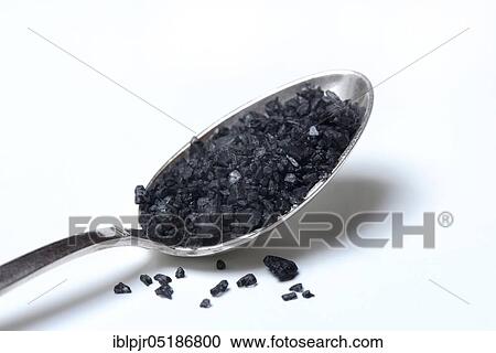 Stock Image - Black Hawaiian salt in spoon, lava salt, sea salt with activated carbon. Fotosearch