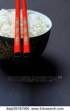 Stock Image - Boiled rice in bowl with chopsticks, basmati rice. Fotosearch
