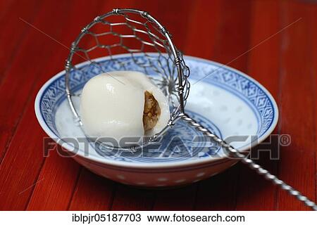 Stock Image - Boiled sticky rice balls with peanut filling. Fotosearch