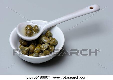 Stock Photo - Bowl and porcelain spoon with capers, inlaid ( Capparis spinosa). Fotosearch
