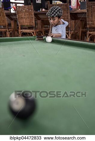 Stock Image - Boy playing billiards, Phnom Penh Province, Cambodia, Asia. Fotosearch