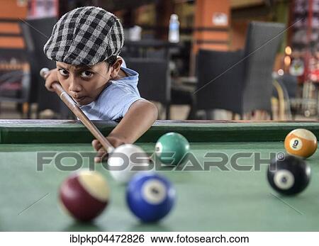 Stock Photograph - Boy playing billiards, Phnom Penh Province, Cambodia, Asia. Fotosearch