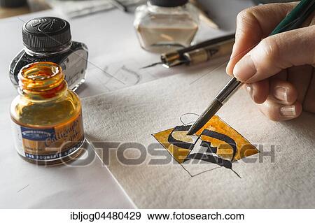 Calligraphy studio, hand paints surface with brush, letter S on torchon paper, inkwells and fountain pen at back, Seebruck, Upper Bavaria, Germany, Europe View Large Photo Image Stock Photo - Calligraphy studio, hand paints surface with brush, letter S on torchon paper, inkwells and fountain pen at back, Seebruck, Upper Bavaria, Germany, Europe. Fotosearch