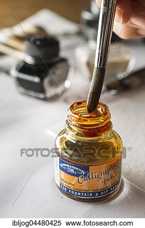 Stock Photography - Calligraphy studio, hand wipes off brush, inkwell at back, Seebruck, Upper Bavaria, Germany, Europe. Fotosearch