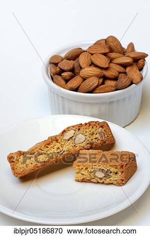 Stock Image - Cantucci and bowl of almonds, cantuccini, almond biscuits from Tuscany, Italy, Europe. Fotosearch