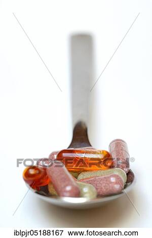 Stock Photo - Capsules on spoon, Omega-3 fatty acids, vitamins, fish oil capsule. Fotosearch