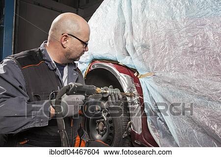 Car bodywork, worker fixing a dent, sheet metal damage on a car fender, Germany, Europe View Large Photo Image Picture - Car bodywork, worker fixing a dent, sheet metal damage on a car fender, Germany, Europe. Fotosearch