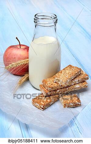 Stock Image - Cereal bar, apple and bottle with milk, power bar. Fotosearch